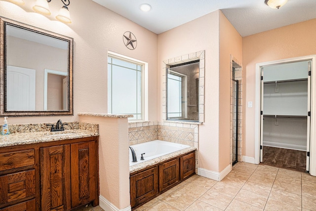 136 Clara Lee Ln, Springtown, TX 76082 - full bathroom with vanity, a bath, a walk in closet, and tile patterned floors
