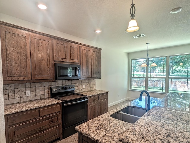 136 Clara Lee Ln, Springtown, TX 76082 - kitchen featuring black appliances, decorative backsplash, hanging light fixtures, light stone counters, and recessed lighting