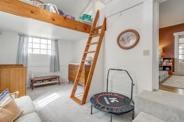 carpeted bedroom with brick wall