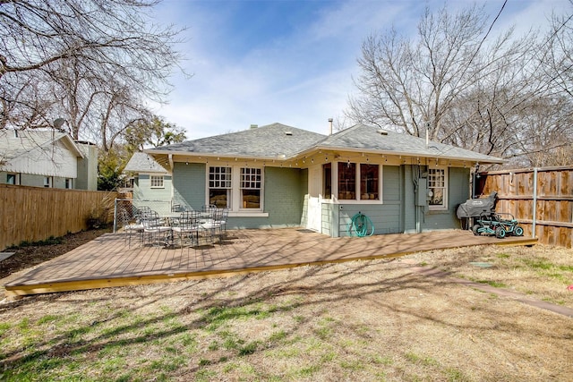 back of property featuring a deck, brick siding, and a fenced backyard