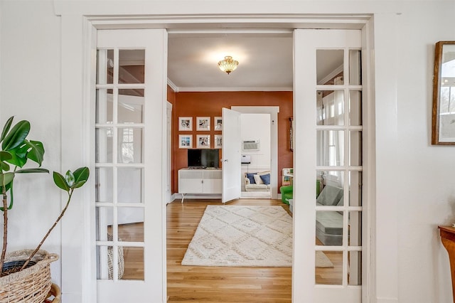 entryway with french doors, ornamental molding, and wood finished floors