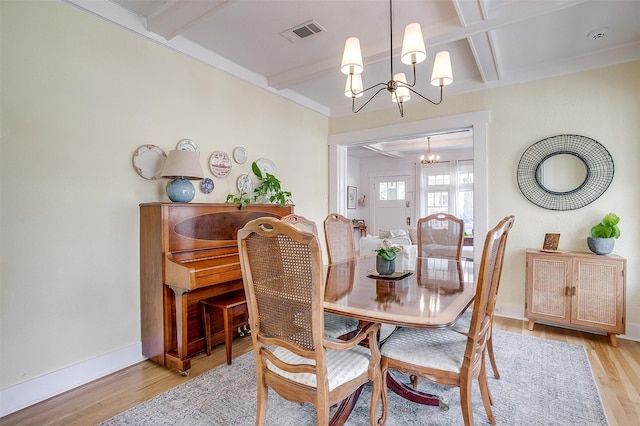 dining space featuring visible vents, baseboards, light wood-type flooring, beamed ceiling, and an inviting chandelier