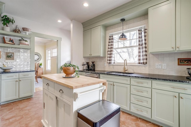 kitchen featuring plenty of natural light, wooden counters, backsplash, and a sink