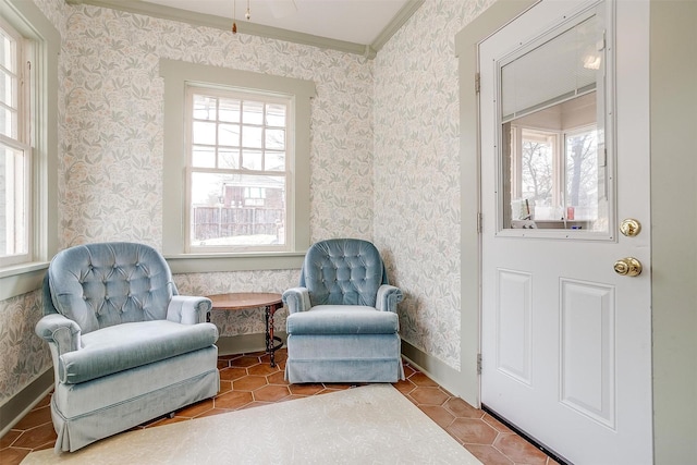 sitting room featuring baseboards, a healthy amount of sunlight, and wallpapered walls