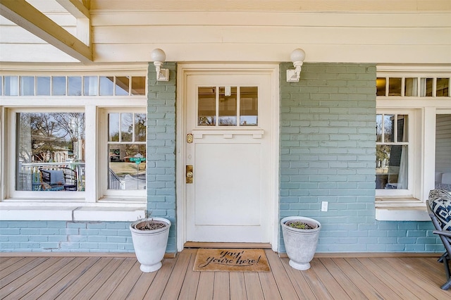 property entrance featuring brick siding and a porch