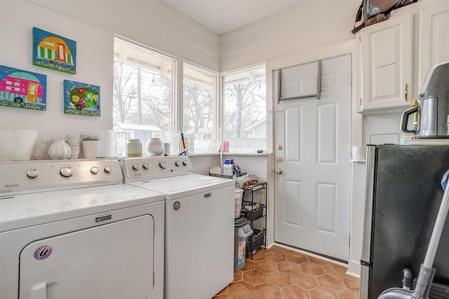 laundry area featuring cabinet space, washer and dryer, and light tile patterned flooring