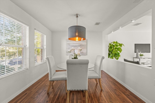 dining room featuring visible vents, baseboards, and wood finished floors