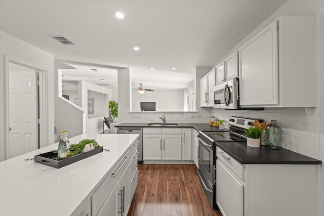 kitchen with visible vents, dark wood finished floors, a sink, stainless steel appliances, and white cabinets