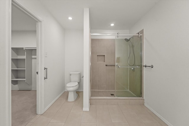 bathroom featuring toilet, a stall shower, and tile patterned flooring