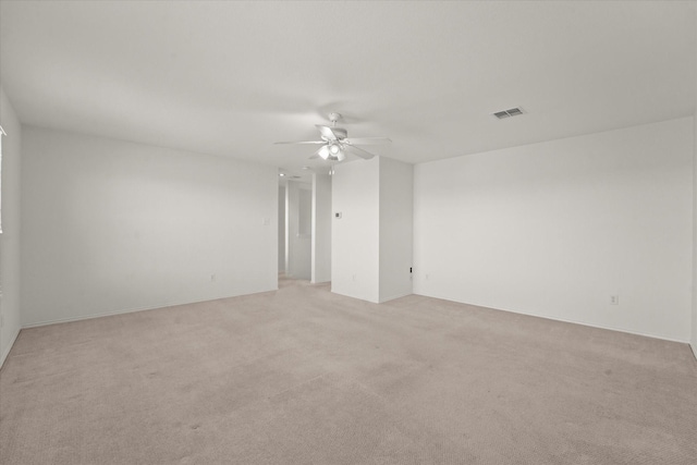 spare room with light carpet, visible vents, and ceiling fan