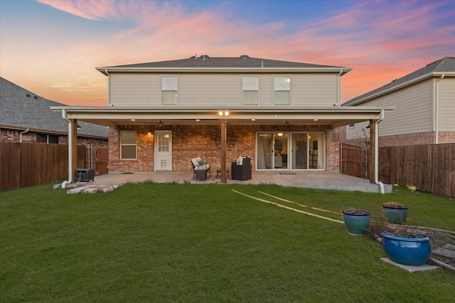 rear view of property with a patio, a yard, and a fenced backyard