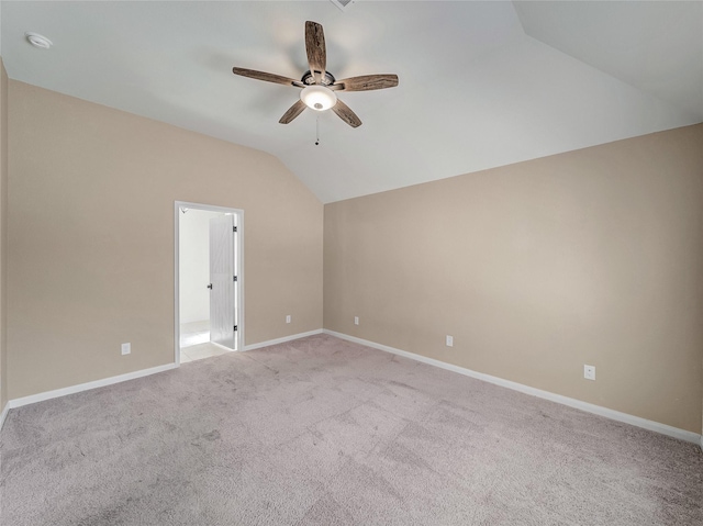 unfurnished room with lofted ceiling, light carpet, a ceiling fan, and baseboards