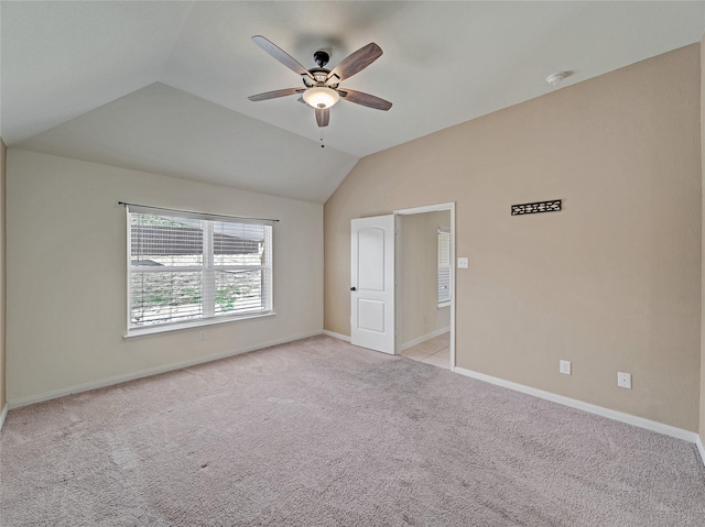 unfurnished bedroom with lofted ceiling, light carpet, ceiling fan, and baseboards