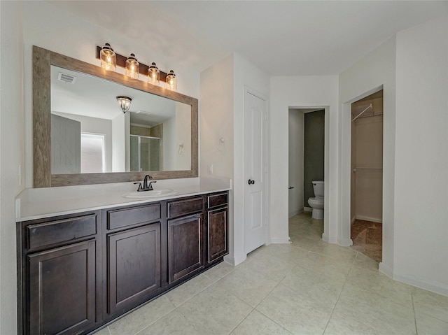 full bath featuring visible vents, a spacious closet, toilet, a stall shower, and vanity