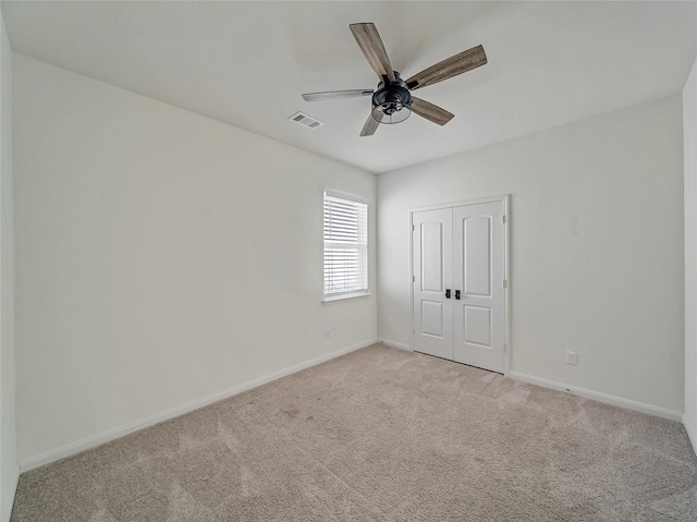 unfurnished bedroom with ceiling fan, light carpet, visible vents, baseboards, and a closet