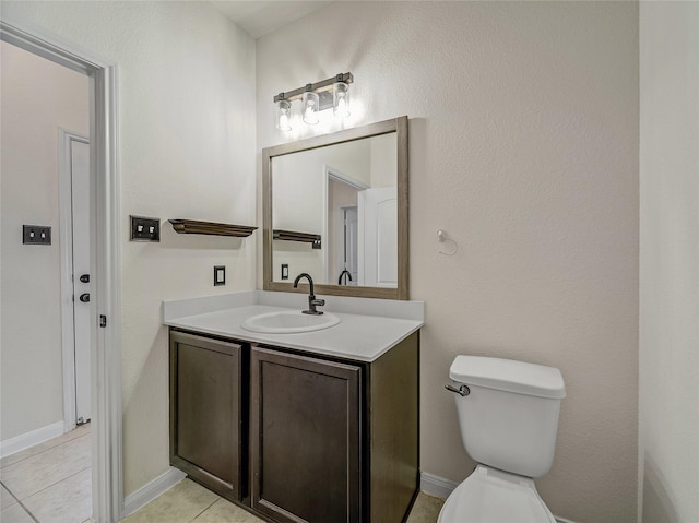 bathroom featuring toilet, baseboards, vanity, and tile patterned floors