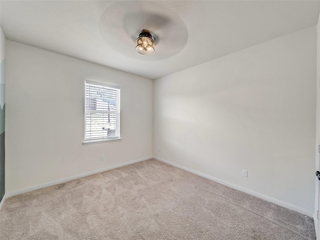 unfurnished room with light carpet and baseboards