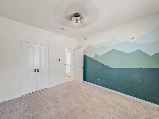 unfurnished bedroom featuring carpet floors, a closet, visible vents, and baseboards