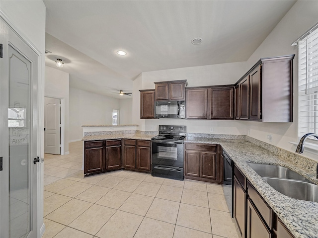 kitchen with light tile patterned floors, a peninsula, a sink, dark brown cabinets, and black appliances