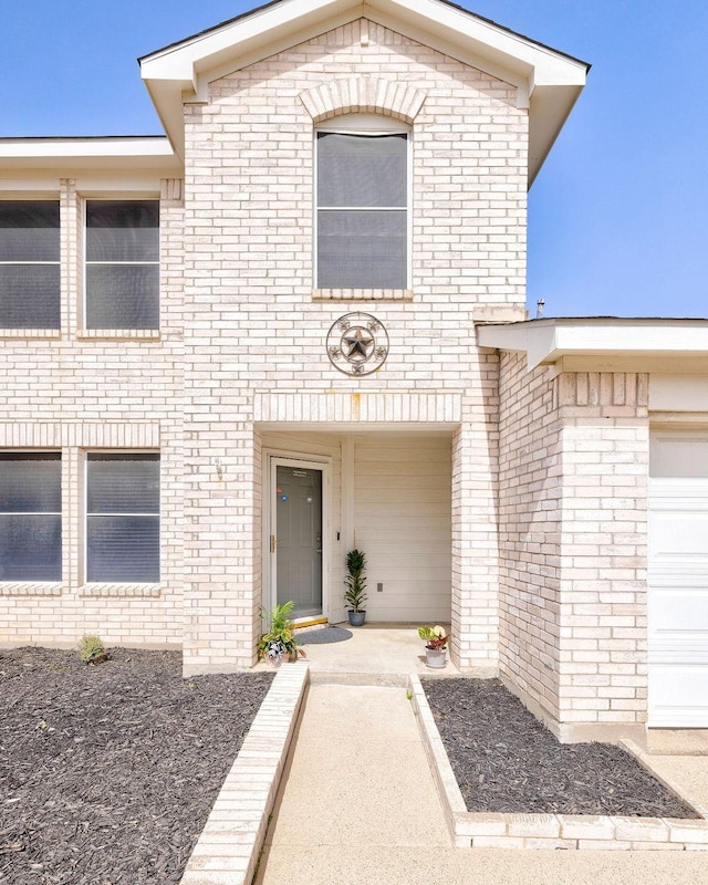 entrance to property featuring brick siding