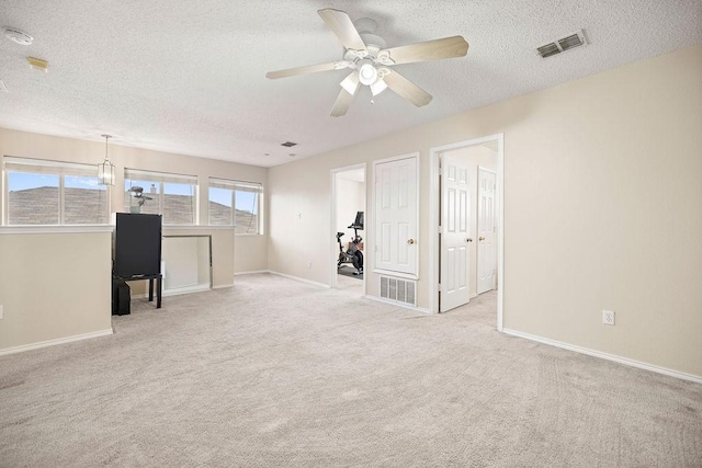 interior space featuring baseboards, visible vents, a textured ceiling, and carpet flooring