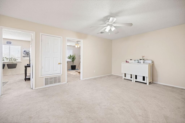 unfurnished room featuring carpet flooring, ceiling fan, and a textured ceiling