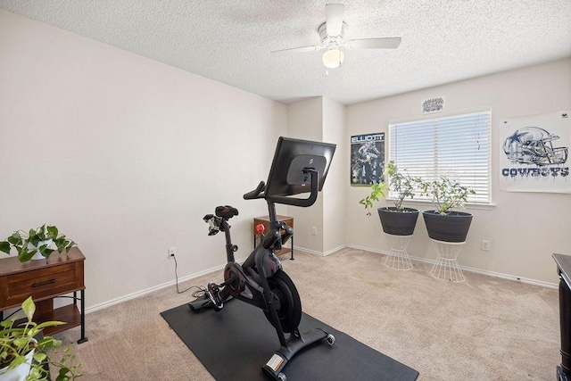 workout room with a ceiling fan, carpet flooring, a textured ceiling, and baseboards