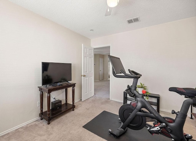 exercise area with a textured ceiling, carpet flooring, visible vents, and a ceiling fan