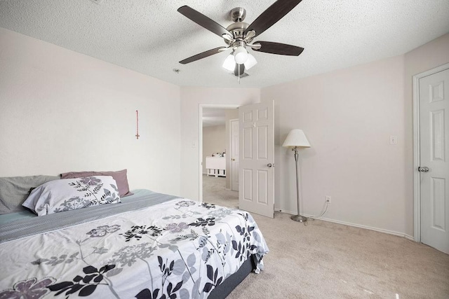 bedroom featuring a ceiling fan, light carpet, a sink, a textured ceiling, and baseboards