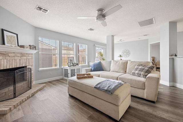 living area with visible vents, a fireplace, and wood finished floors