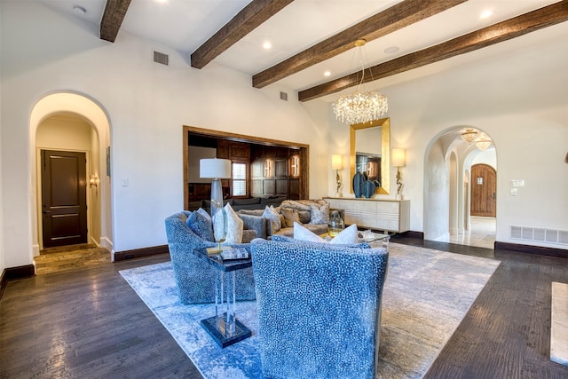 living room with baseboards, visible vents, arched walkways, and wood finished floors