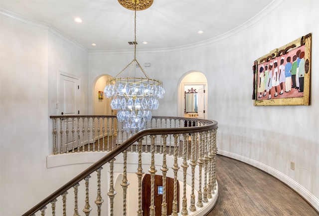 hallway with baseboards, visible vents, ornamental molding, wood finished floors, and an inviting chandelier