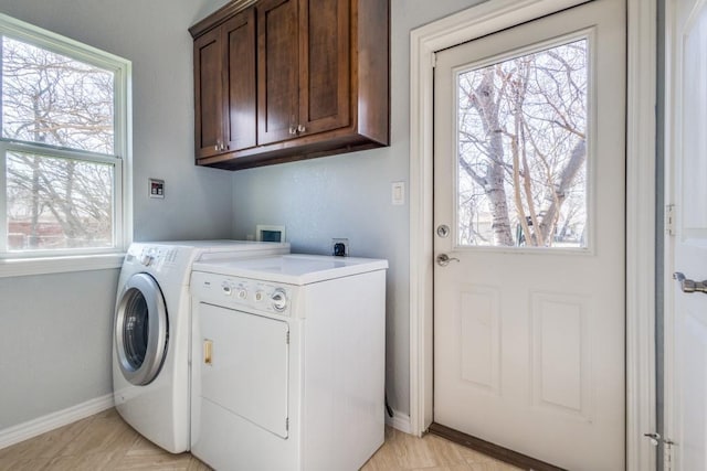 laundry area with baseboards, cabinet space, separate washer and dryer, and plenty of natural light