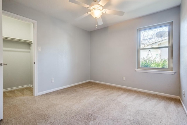 unfurnished bedroom featuring a closet, baseboards, carpet, and a spacious closet