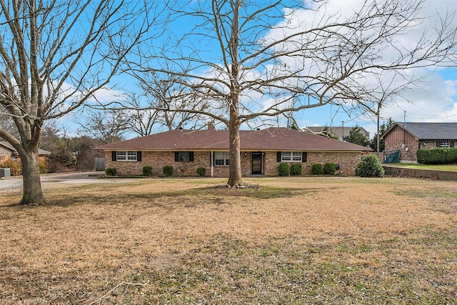 ranch-style home featuring brick siding and a front yard