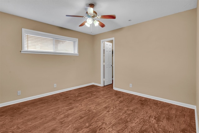 empty room with ceiling fan, wood finished floors, and baseboards