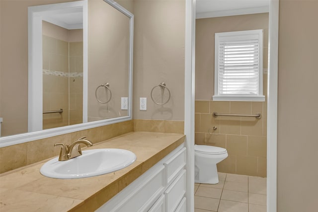 bathroom with toilet, ornamental molding, tile patterned flooring, vanity, and tile walls