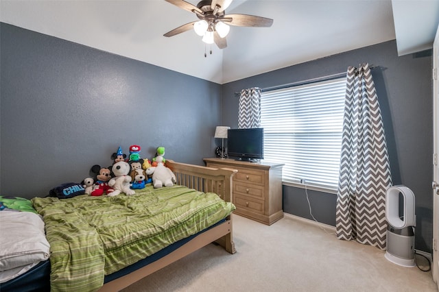 bedroom with a ceiling fan, vaulted ceiling, light colored carpet, and baseboards