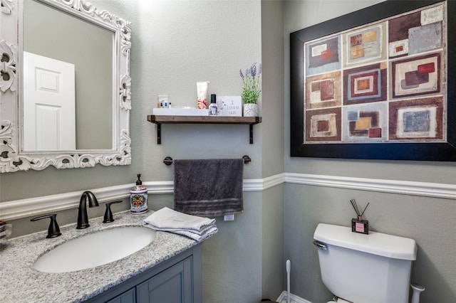 half bathroom with vanity and toilet