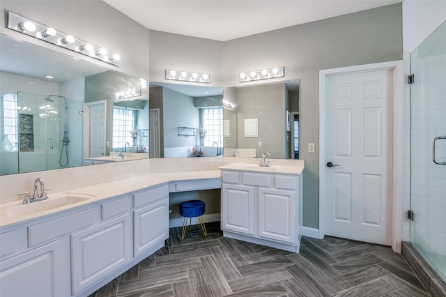 bathroom featuring a shower stall, double vanity, and a sink