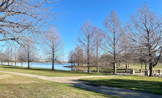 surrounding community featuring a lawn and a water view