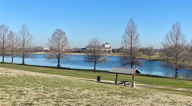 view of home's community featuring a lawn and a water view