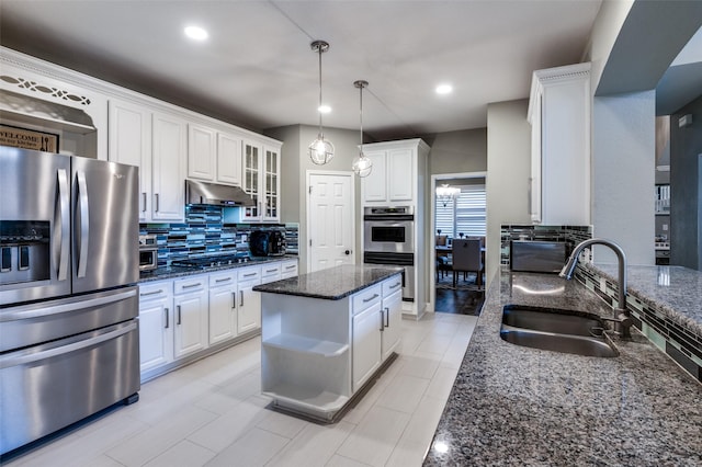 kitchen featuring under cabinet range hood, decorative backsplash, stainless steel appliances, white cabinetry, and a sink