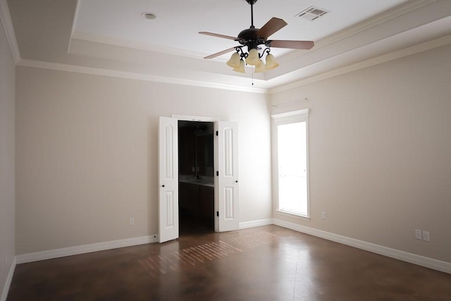 unfurnished room with visible vents, baseboards, a ceiling fan, ornamental molding, and a tray ceiling