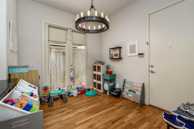 rec room featuring an inviting chandelier and wood finished floors