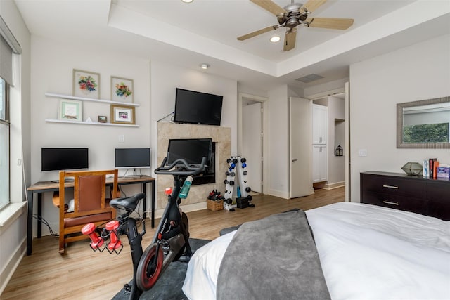 bedroom with a tray ceiling, recessed lighting, and wood finished floors