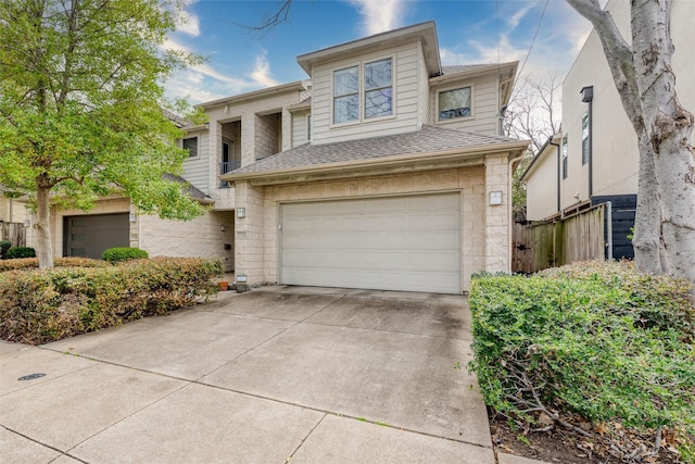 view of front of property featuring an attached garage, driveway, and a shingled roof