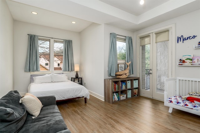 bedroom with access to exterior, recessed lighting, wood finished floors, and french doors