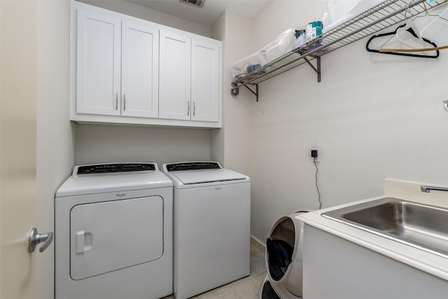 laundry area featuring washing machine and clothes dryer, light tile patterned floors, cabinet space, visible vents, and a sink