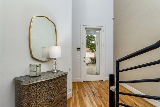 foyer featuring baseboards and wood finished floors